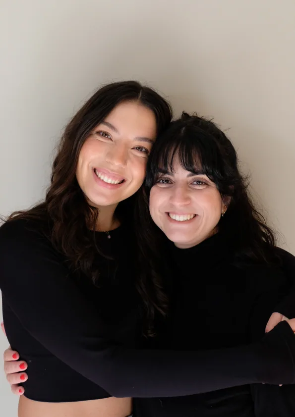 Two friendly team members smiling and embracing — we’d love to hear from you